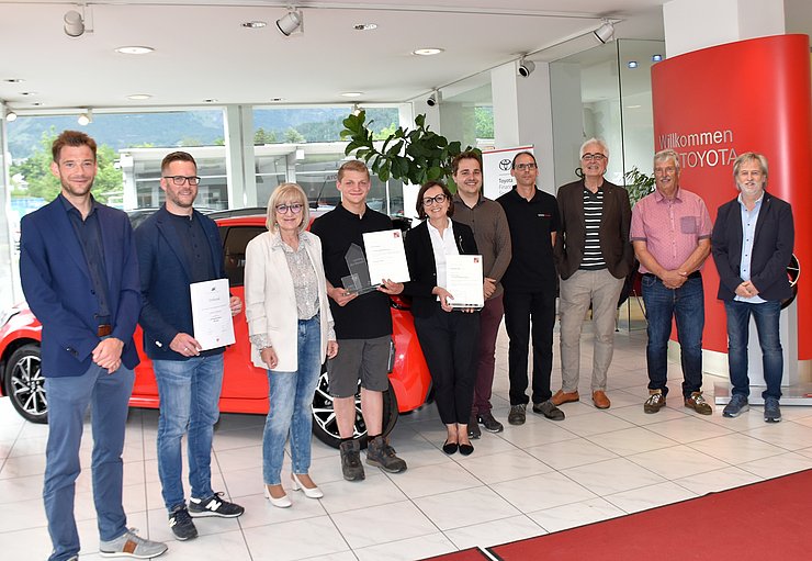 Am Gruppenfoto von links Stefan Wanner (Bezirksstellenleiter Innsbruck-Land Wirtschaftskammer Tirol), Klaus Rainer (Vizepräsident Arbeiterkammer Tirol), Arbeits- und Bildungslandesrätin Beate Palfrader, „Lehrling des Monats Mai 2022“ Lorenz Tschenett, Sonja Bacher (Lehrlings- und Personalbeauftragte (Auto Bacher GmbH), Lukas Bacher, Lehrlingsausbilder Christian Zeller, Firmenchef Willi Bacher, Helmut Pasqualini (Gemeinderat Baumkirchen) und Ernst Römer (Direktor Tiroler Fachberufsschule für KFZ-Technik).