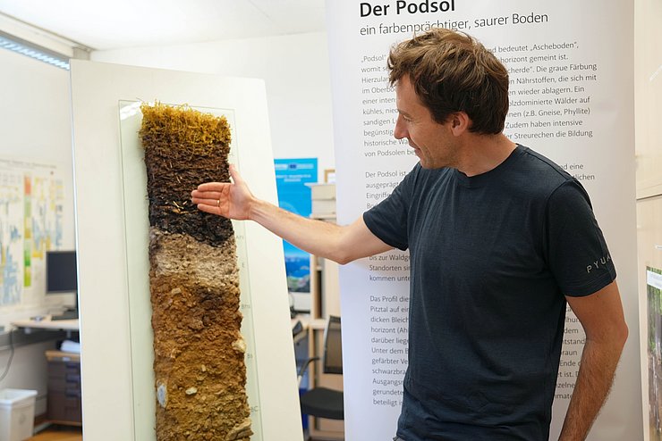 Mann zeigt auf Ausschnitt von Boden