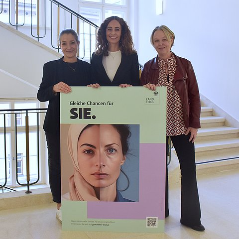 Personen halten großes Plakat (Kapaplatte) mit Sujet: dort sind zwei Gesichtshälften von Frauen zu sehen und der Claim "Gleiche Chancen für SIE."