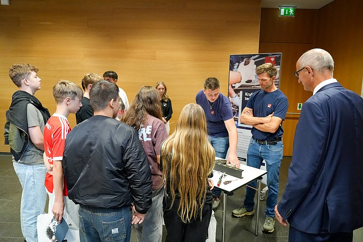 © Land Tirol/Saxl Eine Gruppe von Schülern stehen um einen Messestand. Ganz rechts steht Anton Mattle.