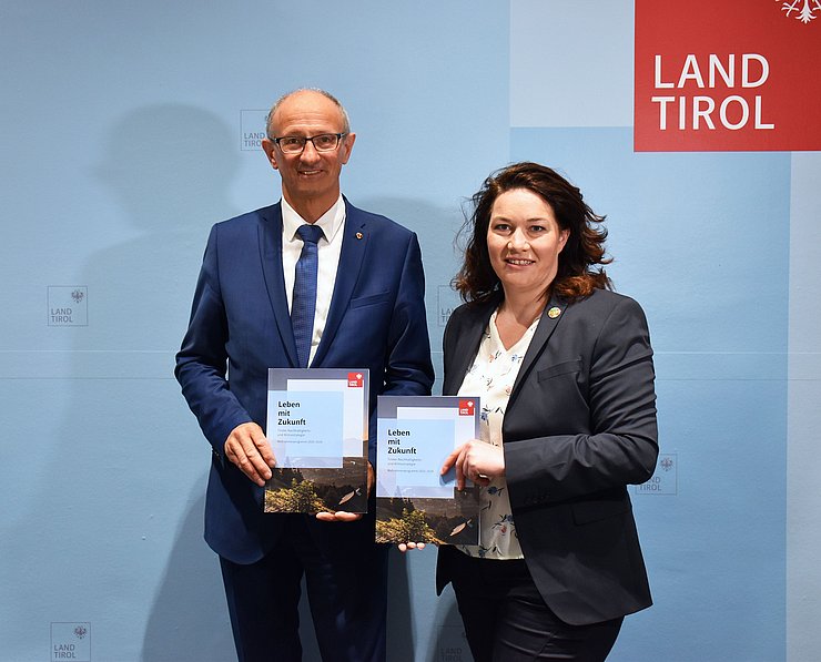 Gemeinsames Foto von Mattle und Felipe mit Klimazielkatalog in der Hand. 