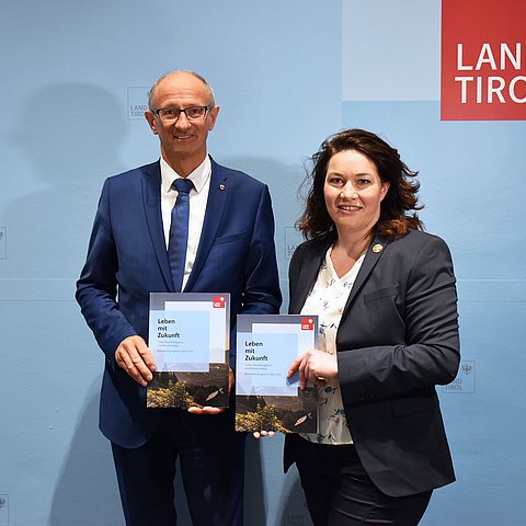 Gemeinsames Foto von Mattle und Felipe mit Klimazielkatalog in der Hand. 