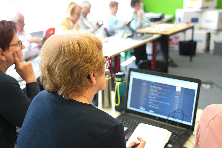 Ältere Frau vor Laptop sitzend