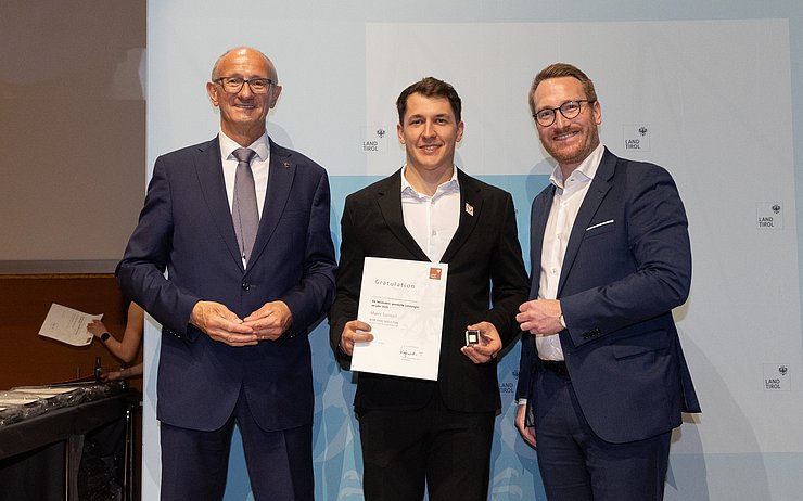 Landeshauptmann Mattle und Landeshauptmann-Stellvertreter Wohlgemuth posieren mit dem Ausgezeichneten.