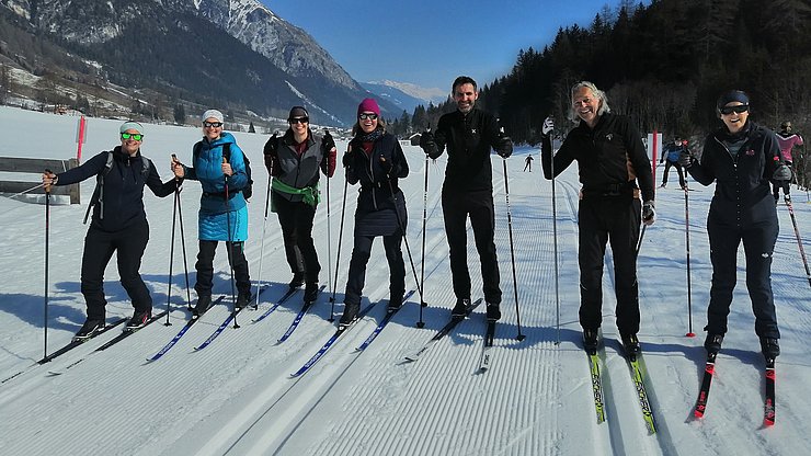 7 Personen mit Langlaufski im Schnee