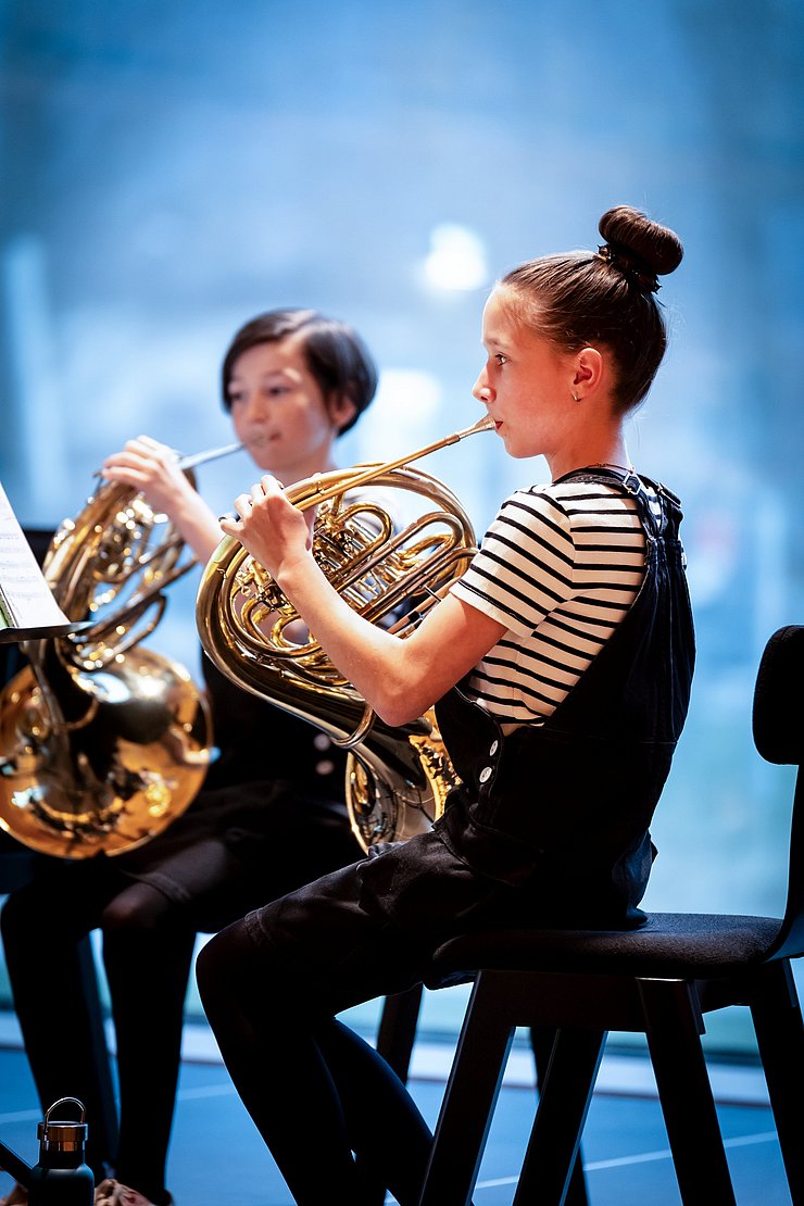 Zwei Mädchen spielen Horn.