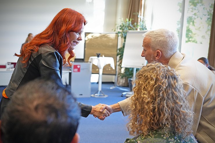 © Land Tirol Cornelia Hagele schüttelt Mann die Hand.