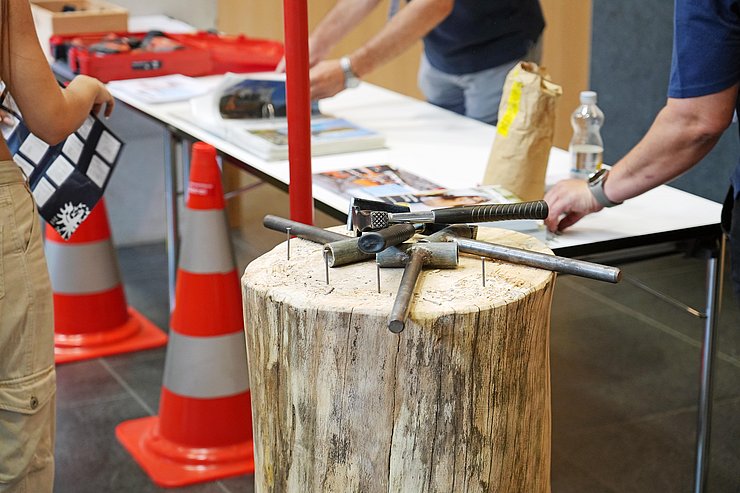 © Land Tirol/Neuner Werkzeug liegt auf einem Baustumpf neben Infostand