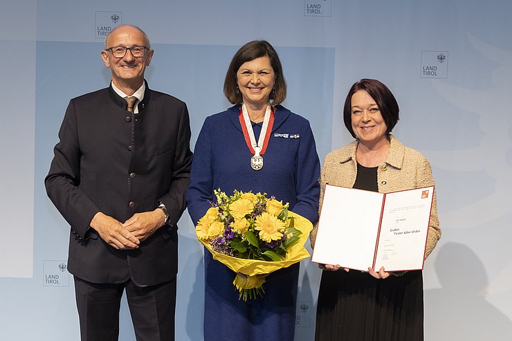 Drei Personen schauen in die Kamera.