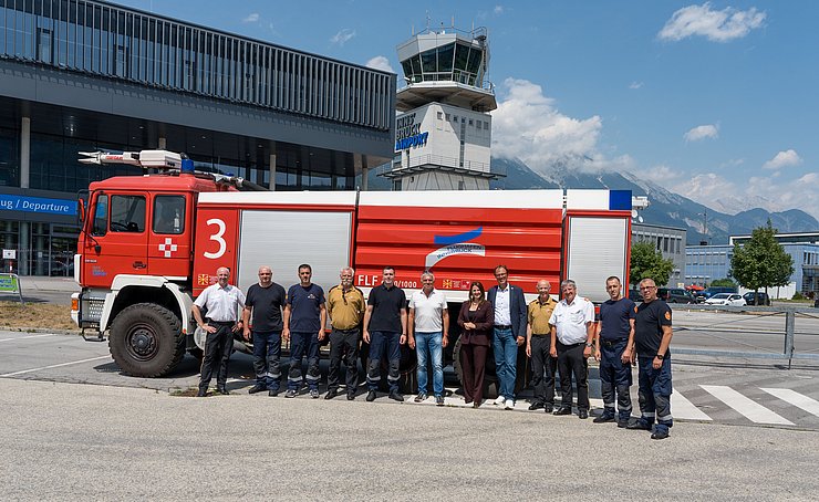Gruppenfoto vor dem Flughafen inklusive Feuerwehrfahrzeug