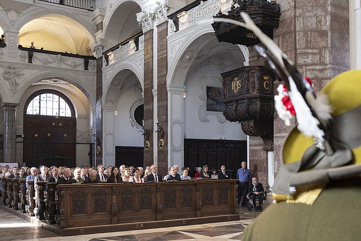 Jesuitenkirche innen: Menschen auf Kirchenbänken sitzend