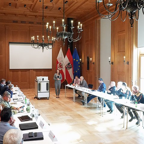 Raum mit Personen an Tisch sitzend