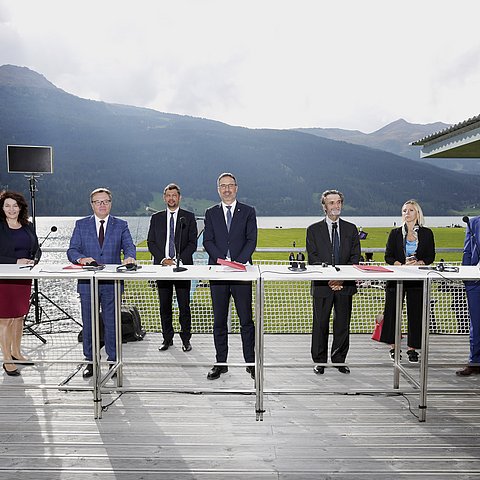 Von links LHStvin Ingrid Felipe, LH Günther Platter, Südtirols Mobilitätslandesrat Daniel Alfreider, Südtirols LH Arno Komatscher, Attilio Fontana, Präsident der Region Lombardei,  Claudia Maria Terzi, lombardische Verkehrsassessorin, und Mario Cavigelli, Regierungsvizepräsident von Graubünden, bei der Unterzeichnung einer Absichtserklärung zur „Verbesserung der grenzüberschreitenden Mobilität in der Terra Raetica, insbesondere im Bereich des öffentlichen Schienenverkehrs“ in Graun am Reschensee.