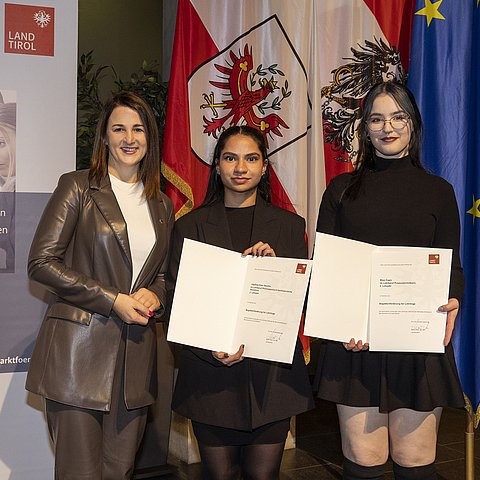 Landesrätin Mair mit zwei ausgezeichneten Lehrlingen.