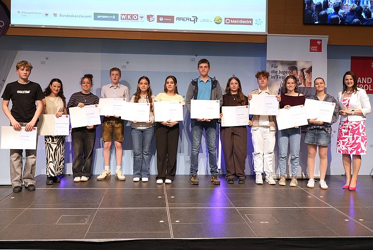 © Land Tirol/Trenker Jugendliche mit Urkunden und eine Frau auf der Bühne