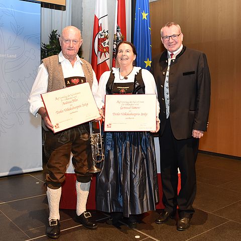 Im Zuge eines offiziellen Festaktes übergibt Landesrat Johannes Tratter (rechts) den Tiroler Volkskulturpreis an Gertraud Patterer sowie Andreas Feller.
