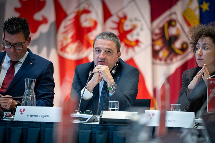 Fugatti stützt sich auf den Ellbogen ab und blickt in die Kamera.
