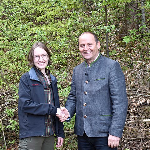 Eva-Maria Kirschner und Landeshauptmann-Stellvertreter beim Händeschütteln im Wald.