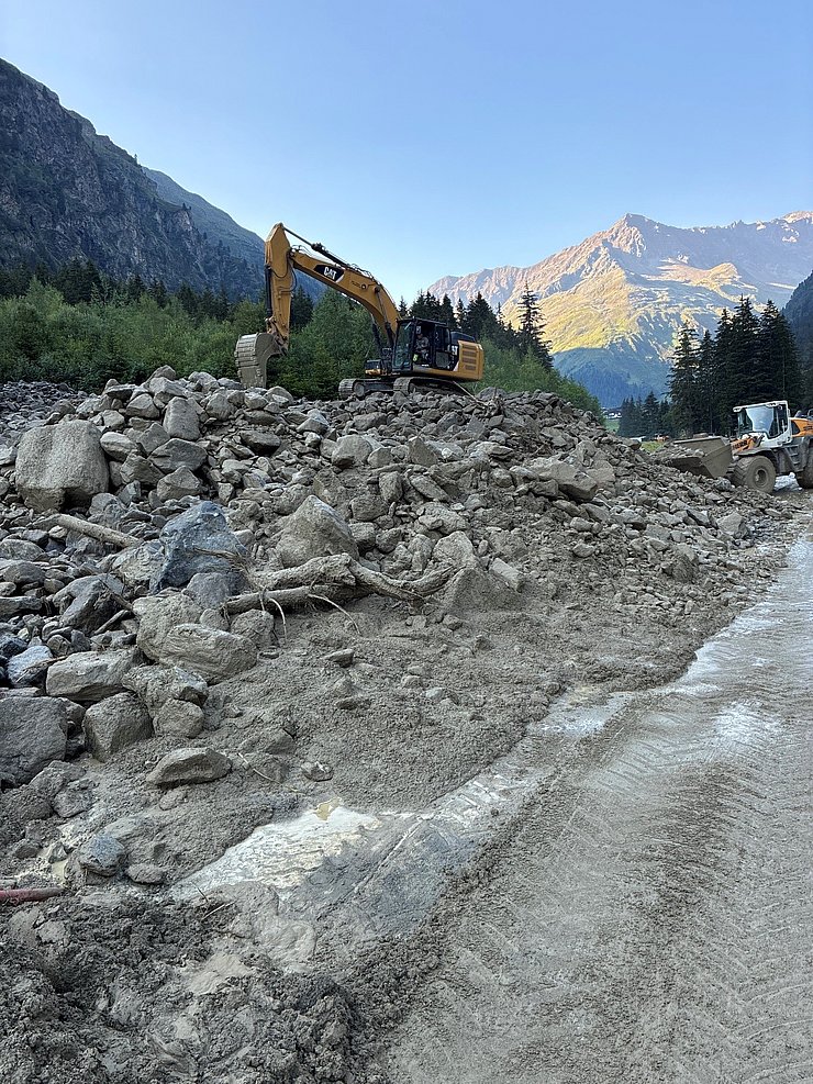 Straße mit Murenmaterial und Bagger