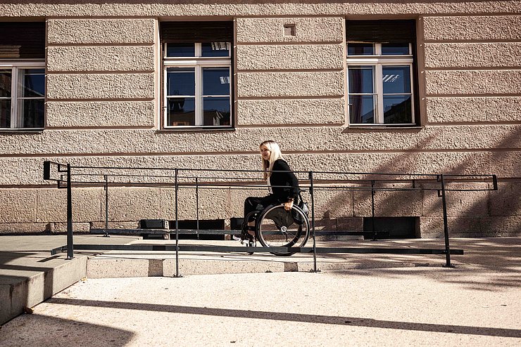Frau im Rollstuhl auf Rampe