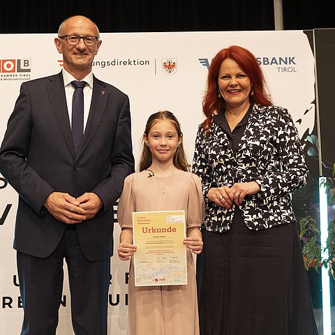 LH Anton Mattle und LRin Cornelia Hagele gratulieren Sandra Weber, der Gewinnerin des tirolweiten Geschichtenwettbewerbs.