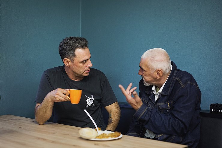 Zwei Personen am Tisch sitzend redend