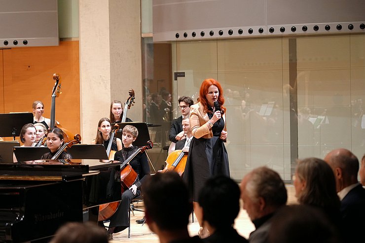 Hagele steht vor einem Orchester.