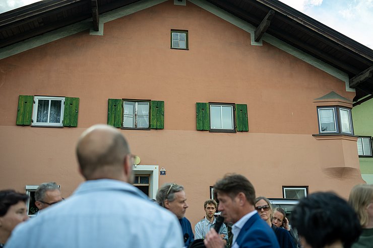 © Keser/BMWKMS Besichtigung der Südtirolersiedlung mit Gebäude im Hintergrund