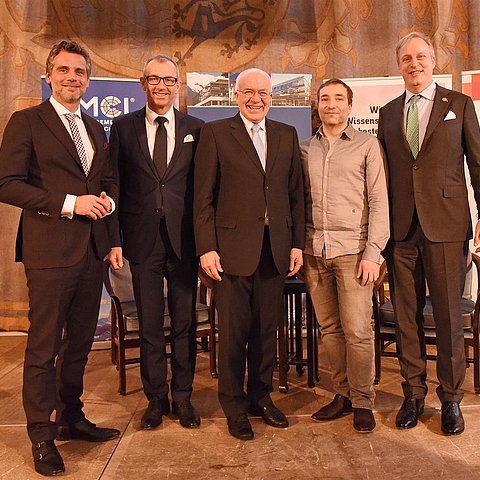 BU: Der frisch gekürte DFK-Ehrenvorsitzende inmitten von Gratulanten im Rahmen der feierlichen Festveranstaltung im Bayerischen Landtag / Maximilianeum: