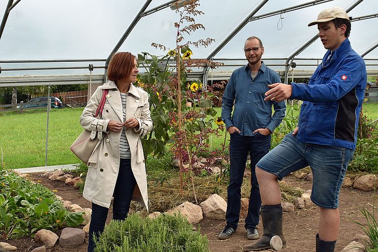 Im IBBA-Gewächshaus werden Kräuter und Gemüse angebaut – das bevorzugte Betätigungsfeld von Fabian Schragl, der sein Fachwissen mit LRin Gabriele Fischer und Geschäftsführer Georg Moser teilt.