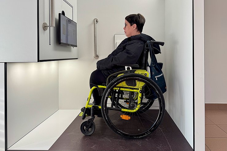 Ein Frau im Rollstuhl befindet sich in einer Fotokabine.