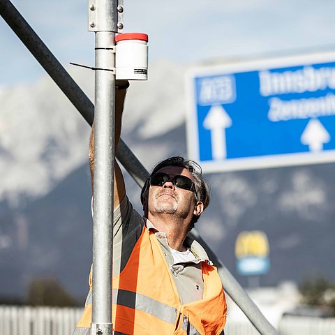 Mann mit Warnweste neben Autobahn 