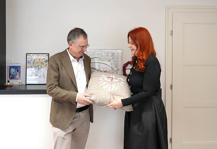 Frau übergibt Mann ein Geschenk