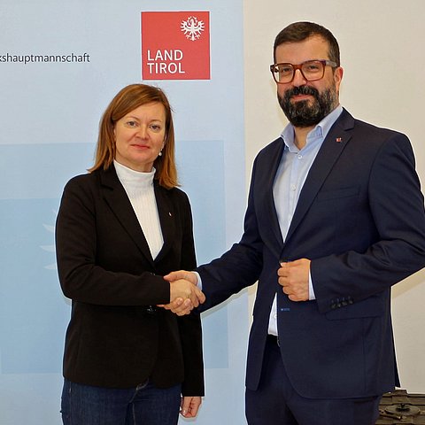 Bezirkshauptfrau Eva Loidhold und Bürgermeister Daniel Raffl schütteln sich die Hände.. 