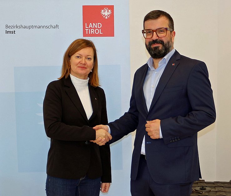 Bezirkshauptfrau Eva Loidhold und Bürgermeister Daniel Raffl schütteln sich die Hände.. 