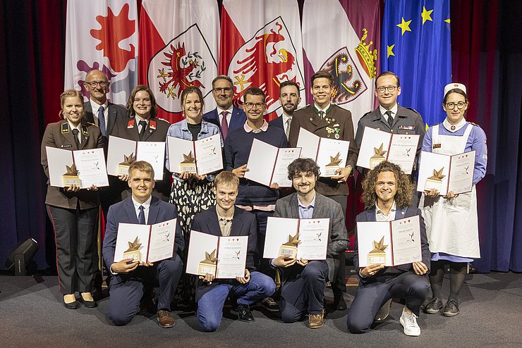 Gruppenfoto, auf dem mehrere junge Menschen eine Urkunde halten.