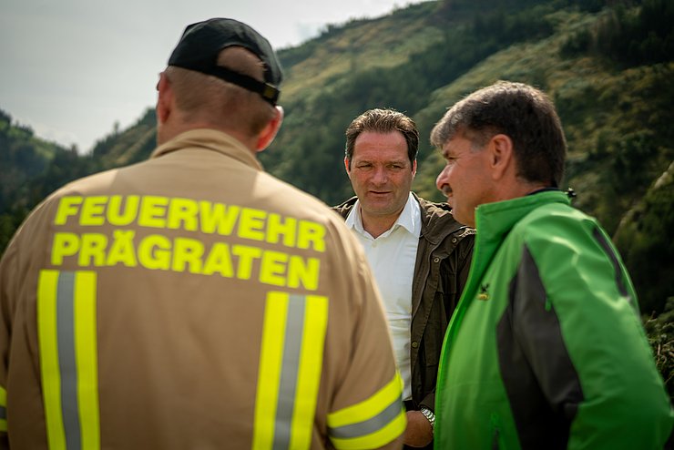 Totschnig mit Ruggenthaler und Feuerwehrmann sprechend