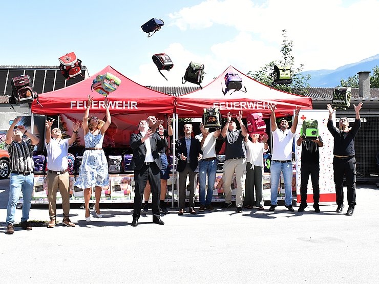 Menschen werfen Schultaschen in die Höhe