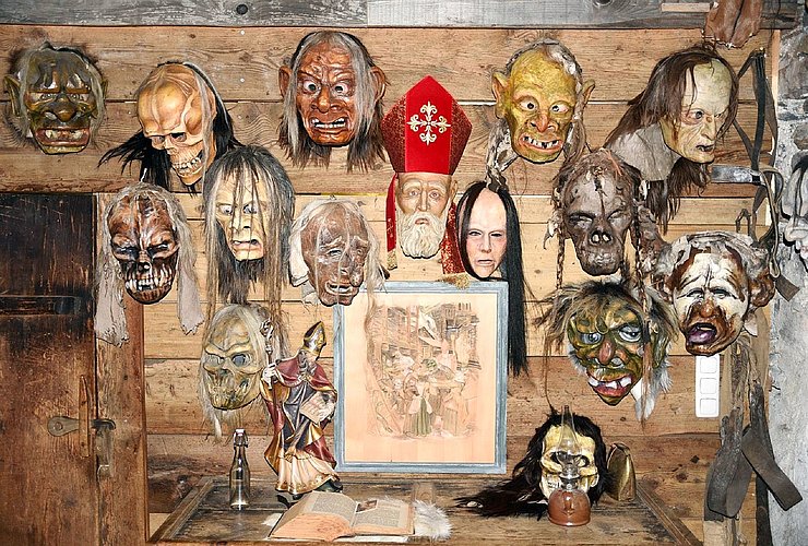 Bretterwand mit aufgehängten Larven im "Klaubaufmuseum im Bäckenstadl" in Lienz, Osttirol.