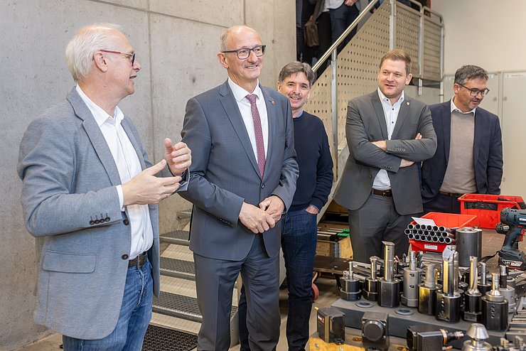 Mann spricht mit Mattle in Betriebshalle