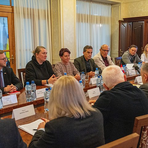 Die Tiroler Abordnung und VertreterInnen der transkarpatischen und des Regionalrats sitzen zu Gesprächen an einem Tisch