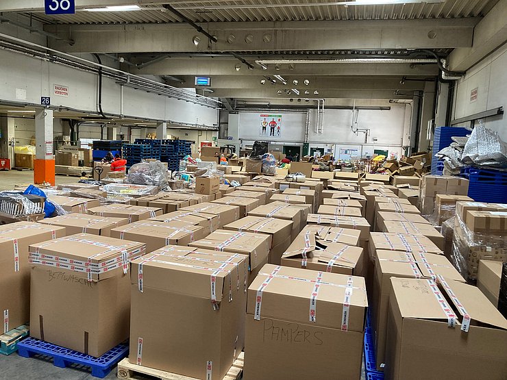 Bild der Halle mit den vielen Paketen mit Sachspenden.