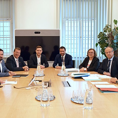 Gruppenfoto; alle sitzen um Tisch