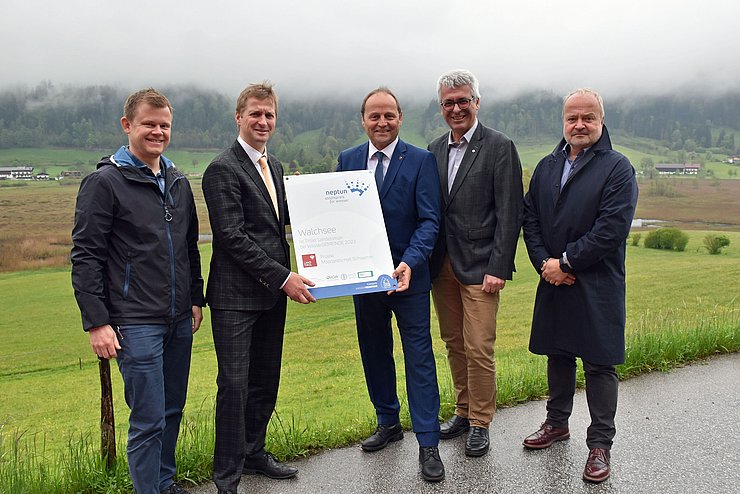 Ein Gruppenfoto auf ein Straße vor einem Feld mit Vizebürgermeister Bernhard Geisler, Bürgermeister Wimmer, Landeshauptmann-Stellvertreter Josef Geisler, Stefan Wildt von der Abteilung Wasserwirtschaft und der Geschäftsführer von TVB Kaiserwinkl Thomas Schönwälder.