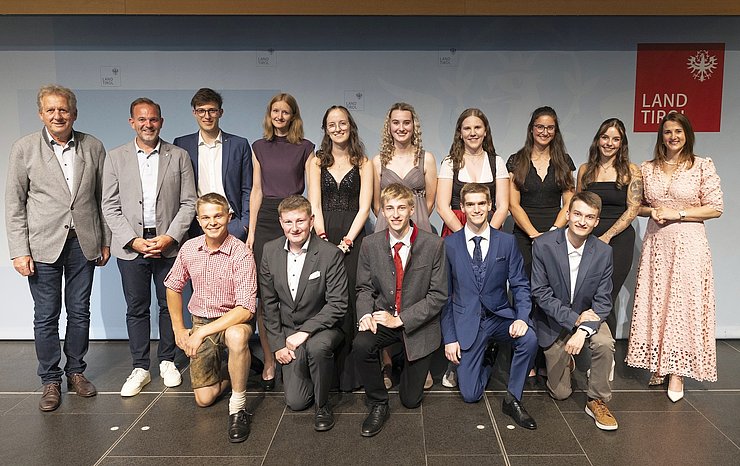 © Land Tirol/Sedlak Gruppenfoto mit den zwölf "Lehrlingen des Monats 2025" auf der Bühne.