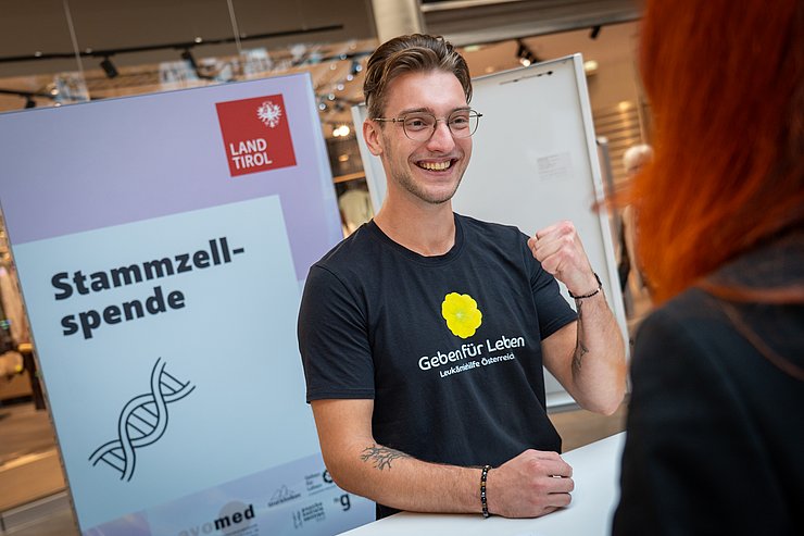 © Land Tirol/Neuner Ein junger Mann bei einem Infostand.