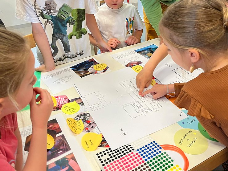 Kinder betrachten einen Bauplan