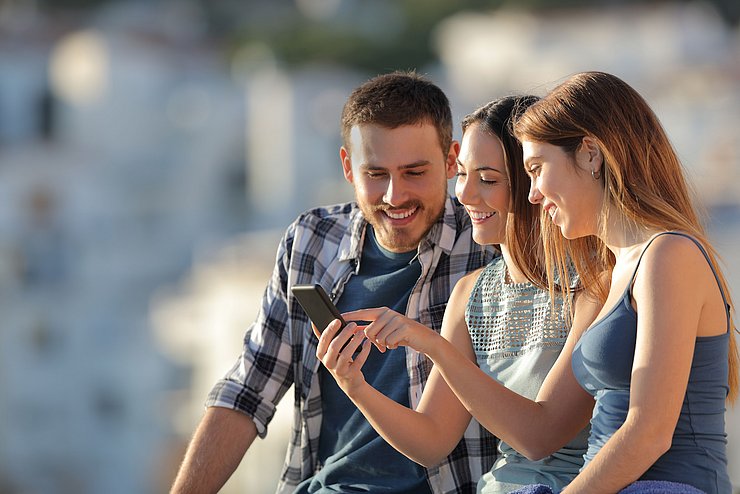 Gruppe von Jugendlichen betrachtet ein Smartphone