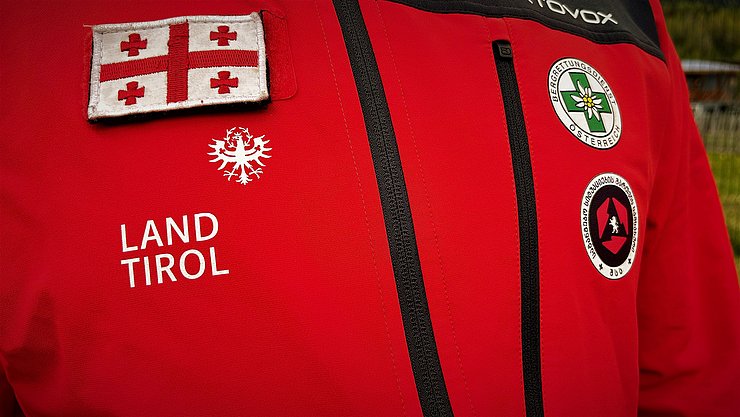 Jacke für Bergrettungseinsätze mit georgischer Flagge, Land Tirol Logo und Bergrettungslogo