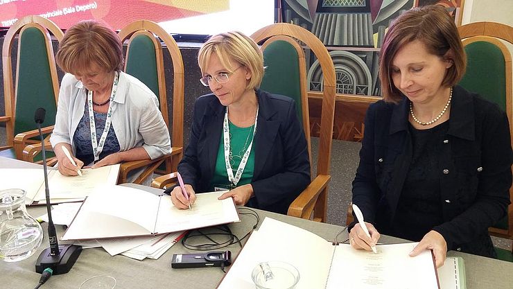 Die drei Euregio-Landesrätinnen unterzeichnen die Resolution, v.re.: LRin Gabriele Fischer (Tirol), LRin Sara Ferrari (Trentino) und LRin Martha Stocker (Südtirol).